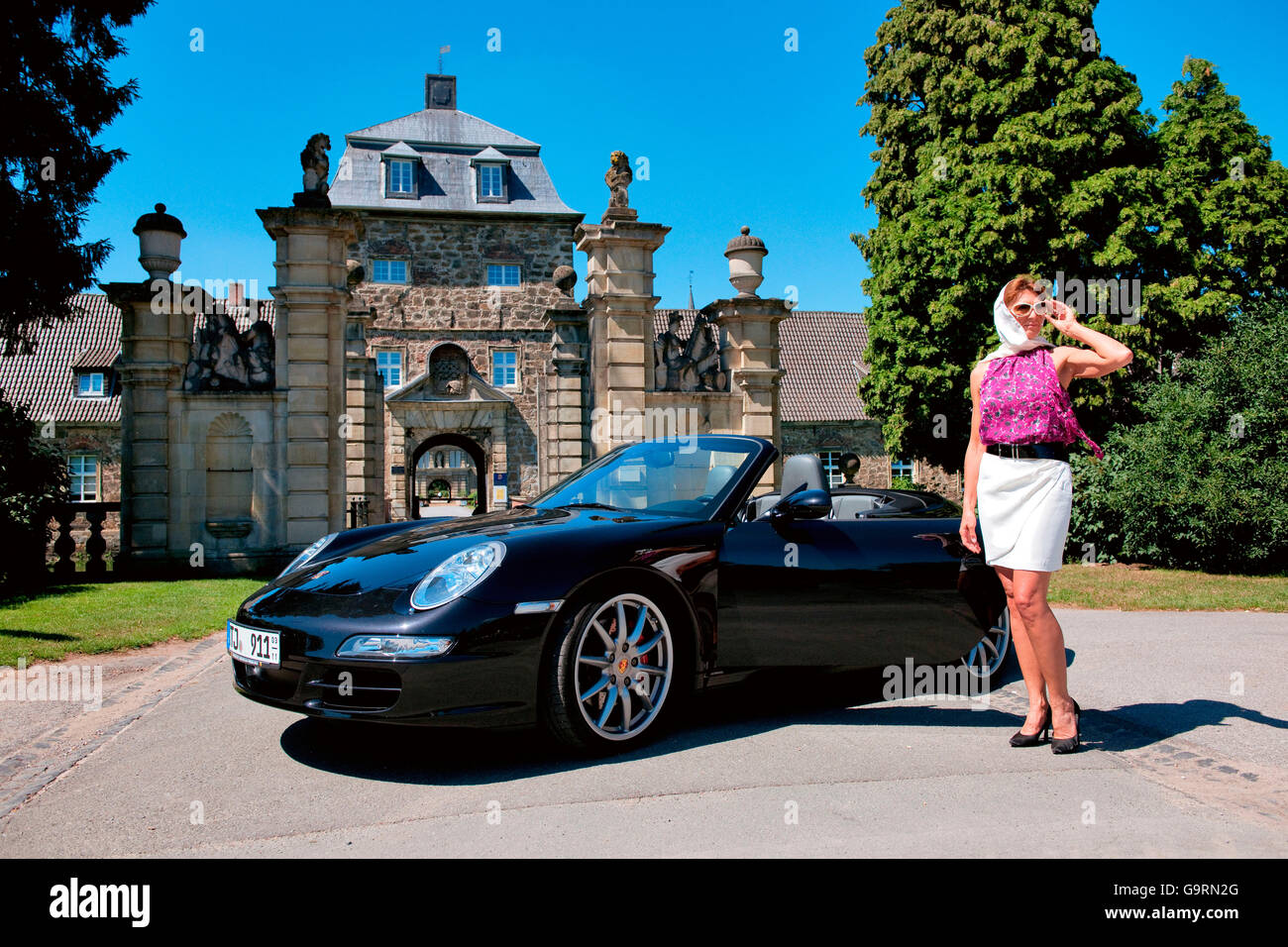stilvolle Frau und Porsche 911 vor Schloss, 911 Carrera 4 s, Cabrio, Sportwagen, Luxus Stockfoto