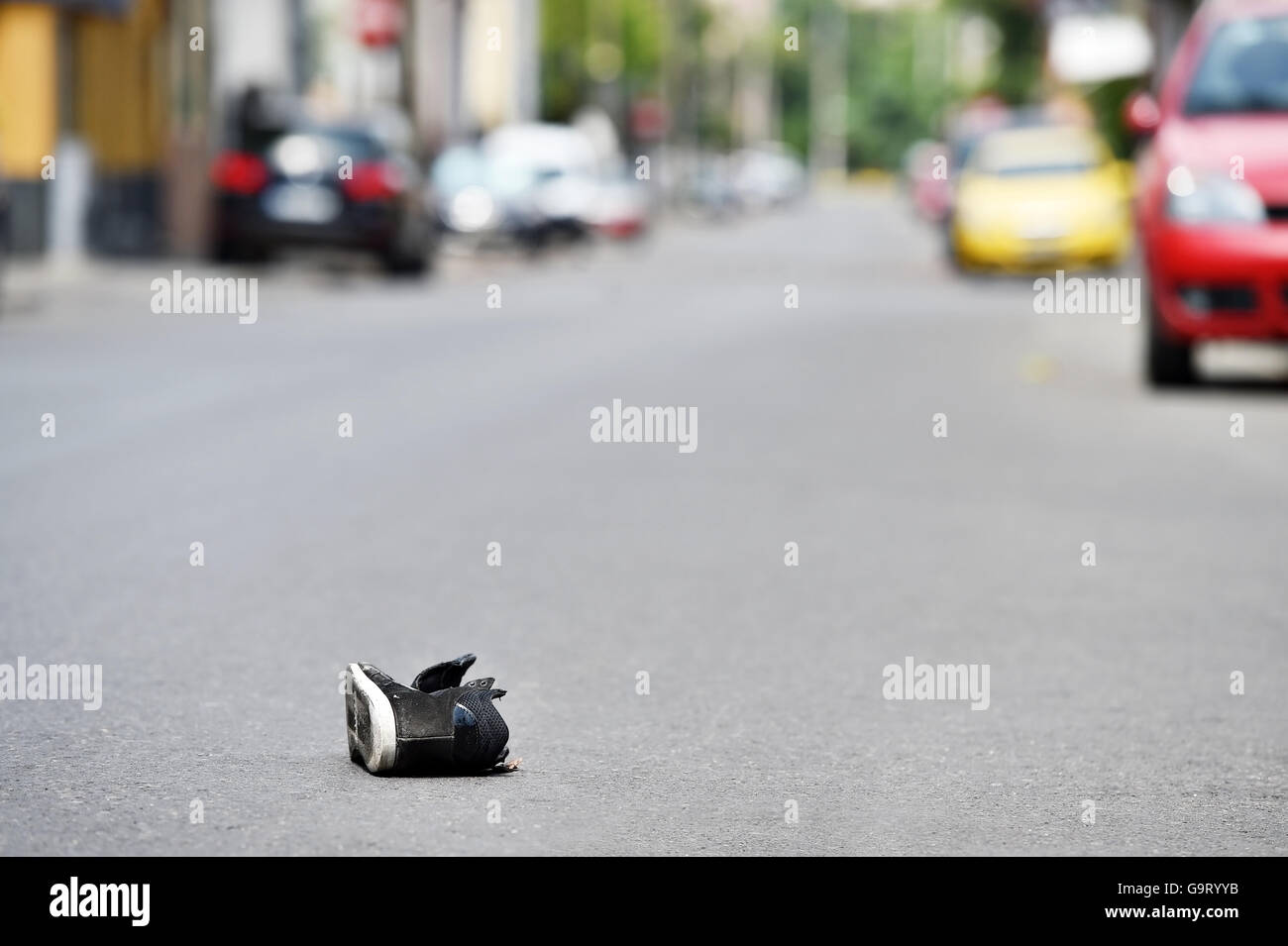 Schuh auf der Straße mit Autos im Hintergrund nach Opfer von Fahrzeug getroffen wurde Stockfoto