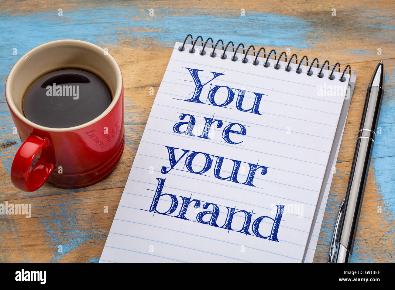 Sie sind Ihre Marke - Motivation Text in Spiral-Notizbuch mit einer Tasse Kaffee Stockfoto
