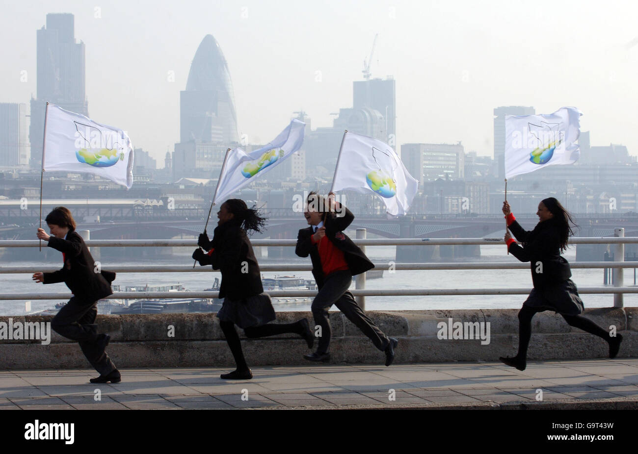 Während der Dreharbeiten zum vorletzten Bein des US-Milliardärsphilanthropen Fred Nassiri, dem größten Musikvideo, das jemals produziert wurde, tragen Kinder Banner am South Bank im Zentrum von London. Stockfoto