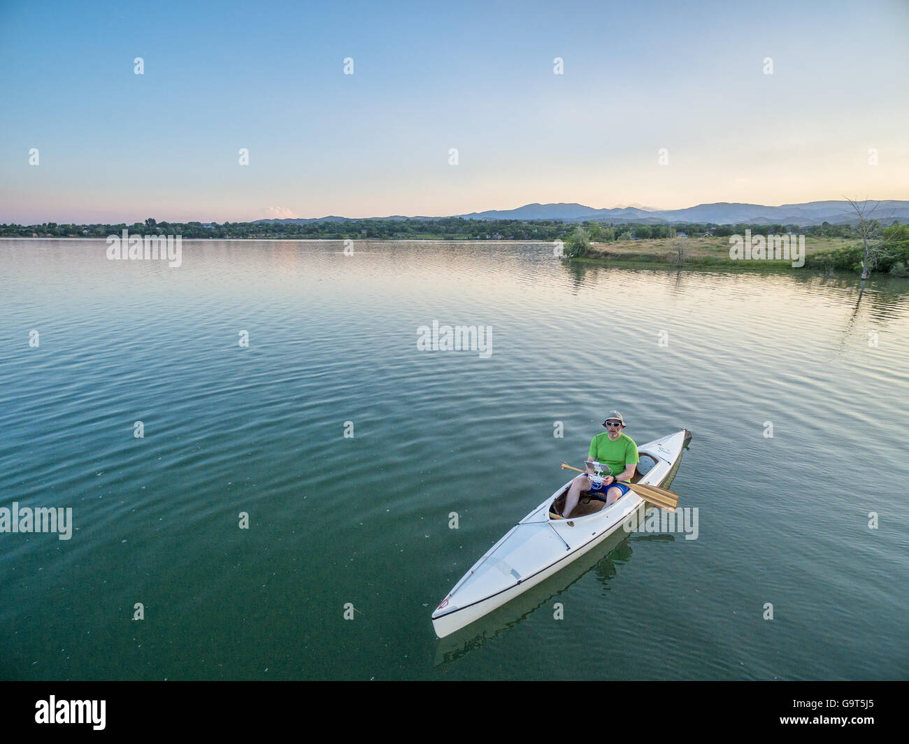 männlichen Paddler betreibt eine Drohne vom Kanu auf dem See, Luftbild Stockfoto
