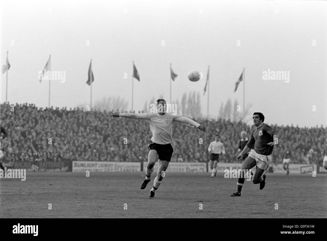 (L-R) Fulhams George Cohen und Ian Story-Moore von Nottingham Forest jagen einem springenden Ball nach Stockfoto