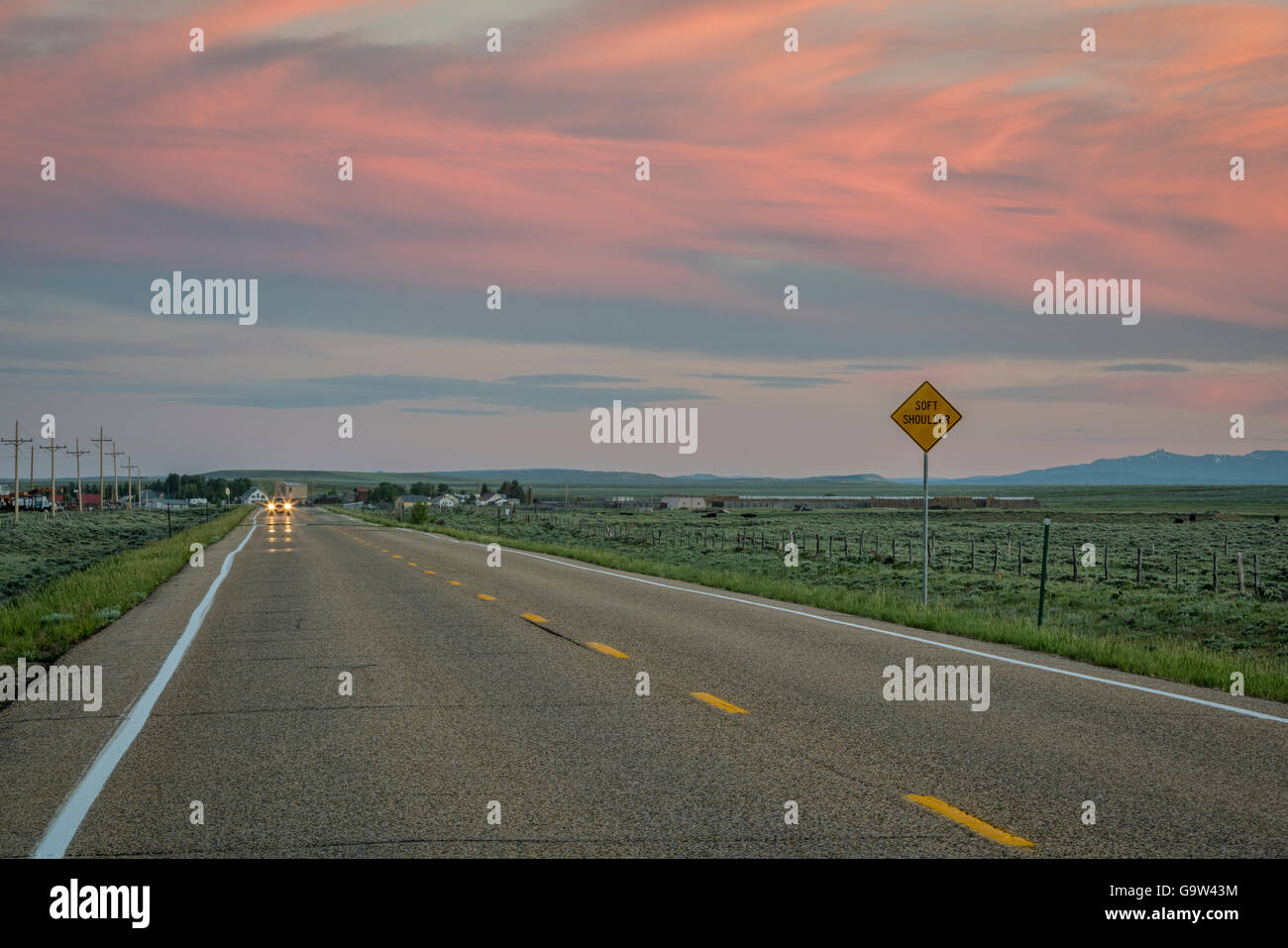 Autobahn in der Abenddämmerung mit rosa Himmel in der Nähe von Cowdrey, North Park, Colorado Stockfoto