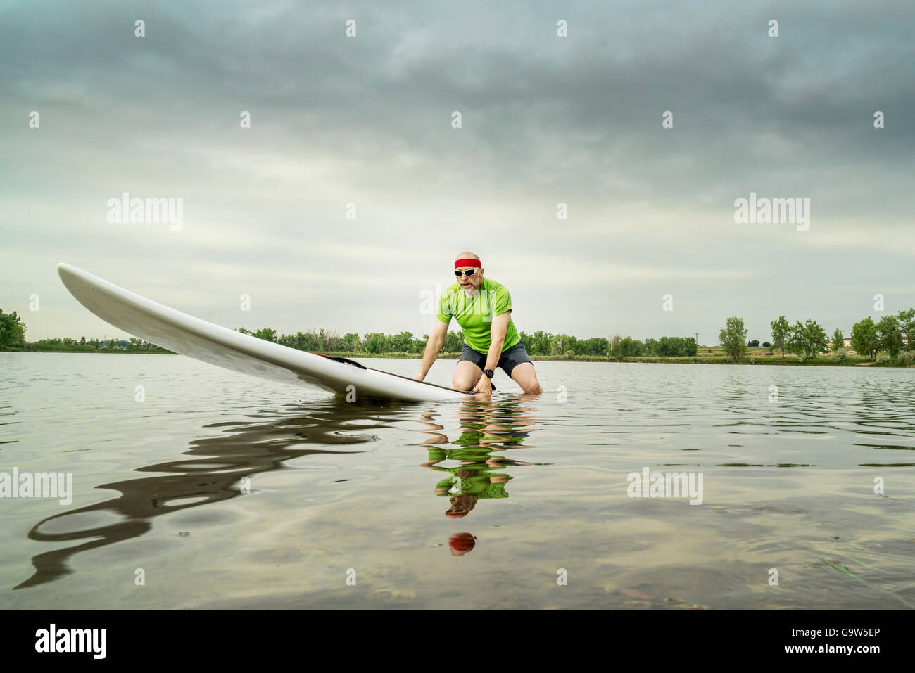 Senior männlichen Paddler auf einem Paddleboard, See im nördlichen Colorado, Clody Sommermorgen Stockfoto