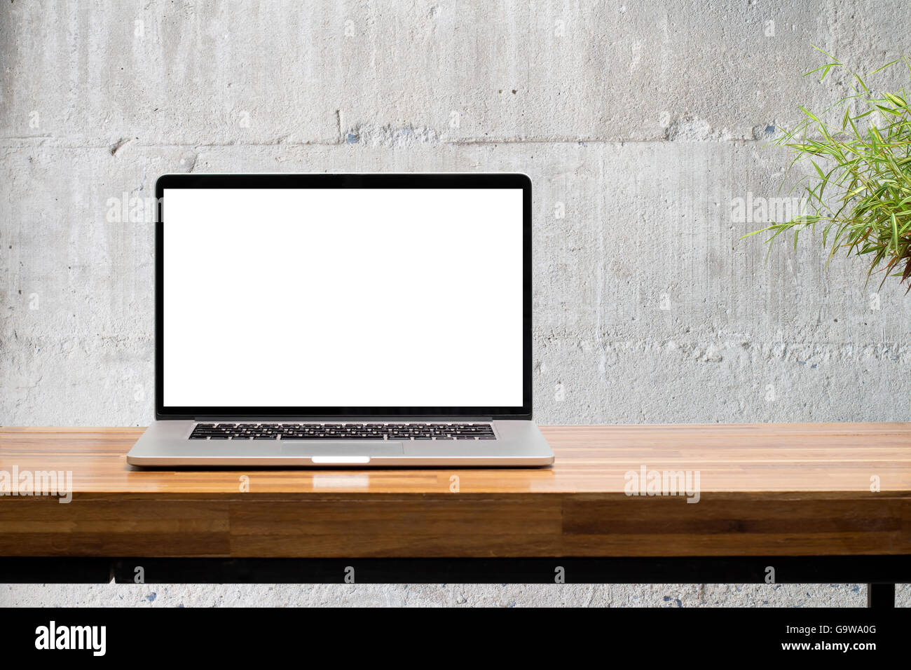 Laptopbildschirm auf Holztisch mit Betonmauer Hintergrund Stockfoto