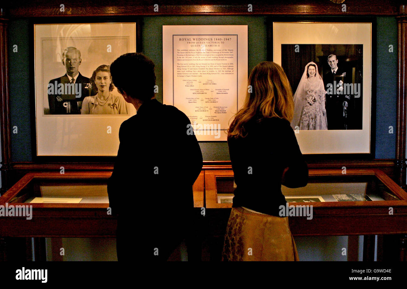 Zwei Damen sehen den königlichen Stammbaum und begleitende Porträts in einer Ausstellung in Windsor Castle, Berkshire. Stockfoto
