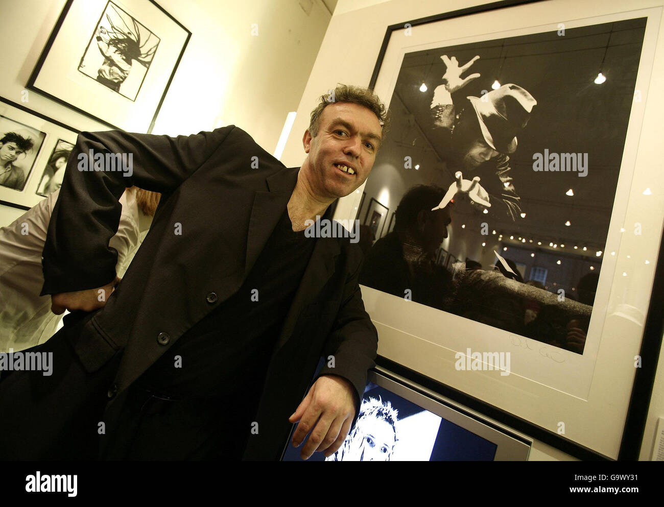 Der Fotograf David Corio ist neben einem seiner Bilder von Tom Waits zu sehen, in einer privaten Ansicht der Fotografien seiner Musikfotografie mit dem Titel 'Moirs from the Mosh-Pit', in der Rocharchive Gallery in Chelsea, West London. Stockfoto