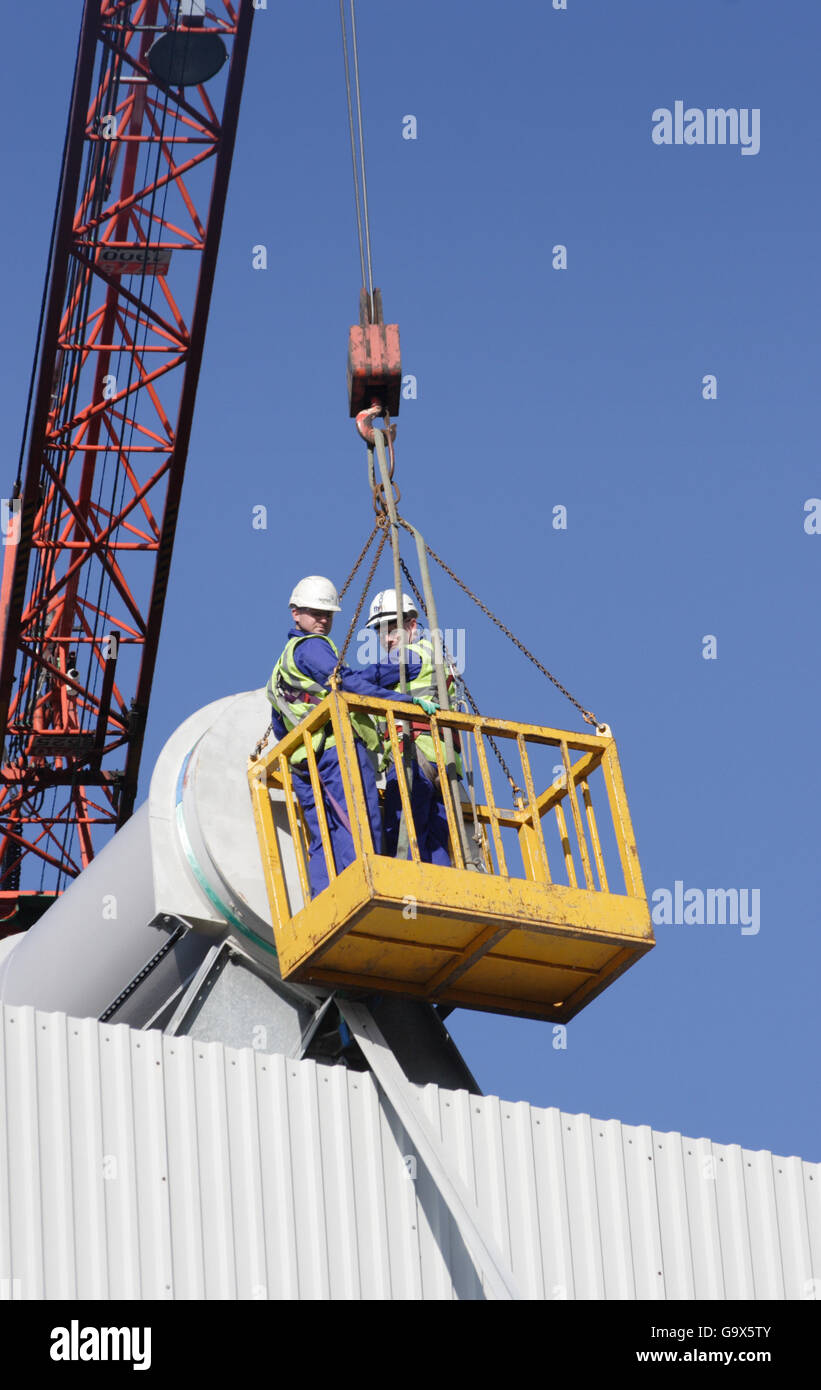 Zwei Arbeiter auf das Dach einer Industrieanlage mit einer Docking-Station mit einem Kran gehoben zugreifen. Stockfoto