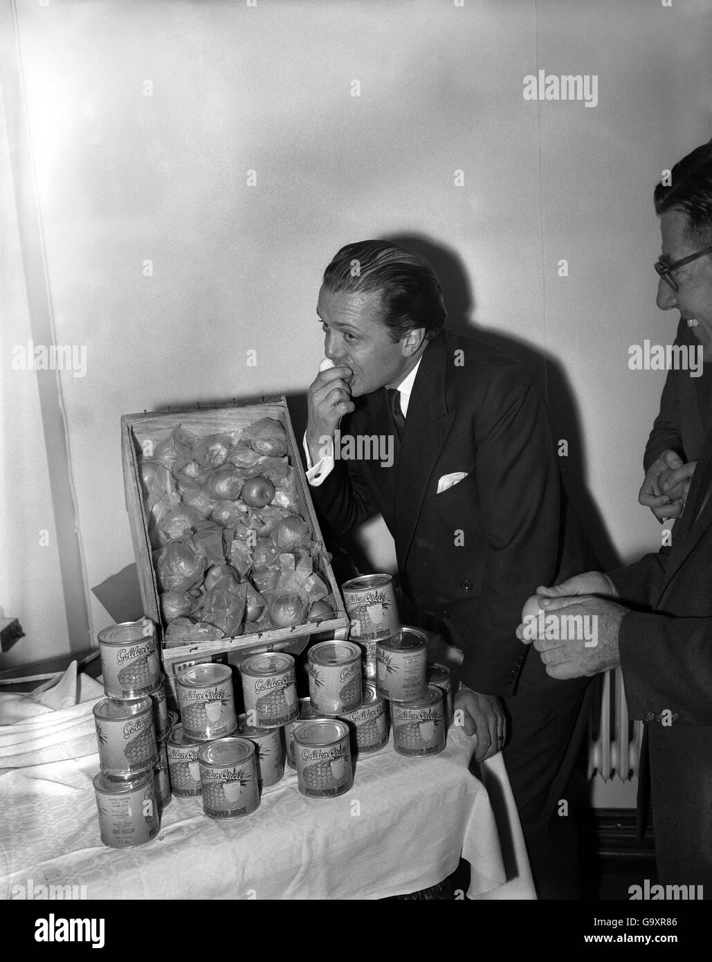 Filmstar Richard Attenborough konnte nicht widerstehen, diese köstliche Lieferung von Granny Smith Äpfeln zu probieren. Das Geschenk von Sabrina - jetzt in Australien unterwegs - an das Actor's Waisenhaus. 14/8/1959 Stockfoto