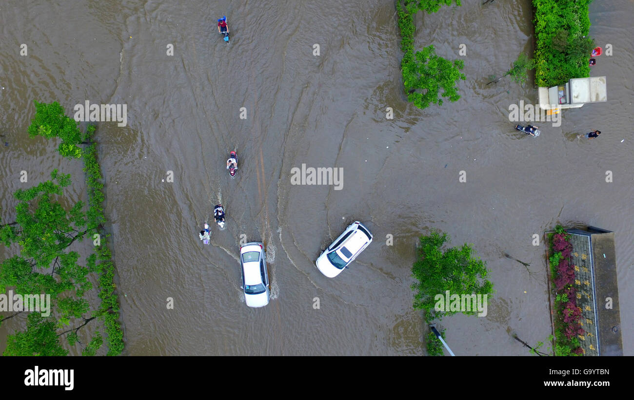 Yangzhou, China Jiangsu Provinz. 5. Juli 2016. Menschen und Fahrzeuge bewegen in einer aufgeweichten Straße in Yangzhou, der ostchinesischen Provinz Jiangsu, 5. Juli 2016. Ein Gewitter getroffen Yangzhou Dienstag. Bildnachweis: Wang Qingchao/Xinhua/Alamy Live-Nachrichten Stockfoto