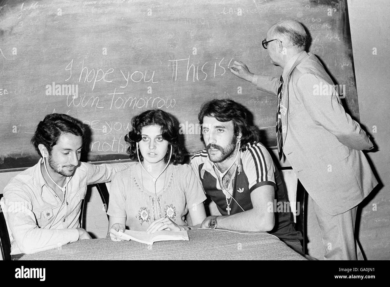 Die argentinischen und Tottenham Hotspur-Spieler Osvaldo Ardiles (l) und Ricardo Villa (r) und Vila's Frau Christina (Mitte) beim englischunterricht bei der East Grinstead-Firma von Interlingua. Ihr Tutor Matthew Burran (ganz rechts) lehrt die Phrase „Ich hoffe, dass du morgen gewinnst“ auf dem schwarzen Brett. Stockfoto