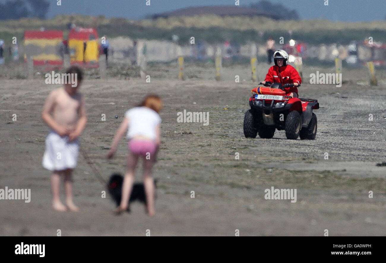 Ein Rettungsschwimmer auf einem Quad-Bike fährt entlang Dollymount Strand, Dublin, das es versäumt hat, den begehrten Blue Flag-Status für ökologische Exzellenz zu sichern. Stockfoto
