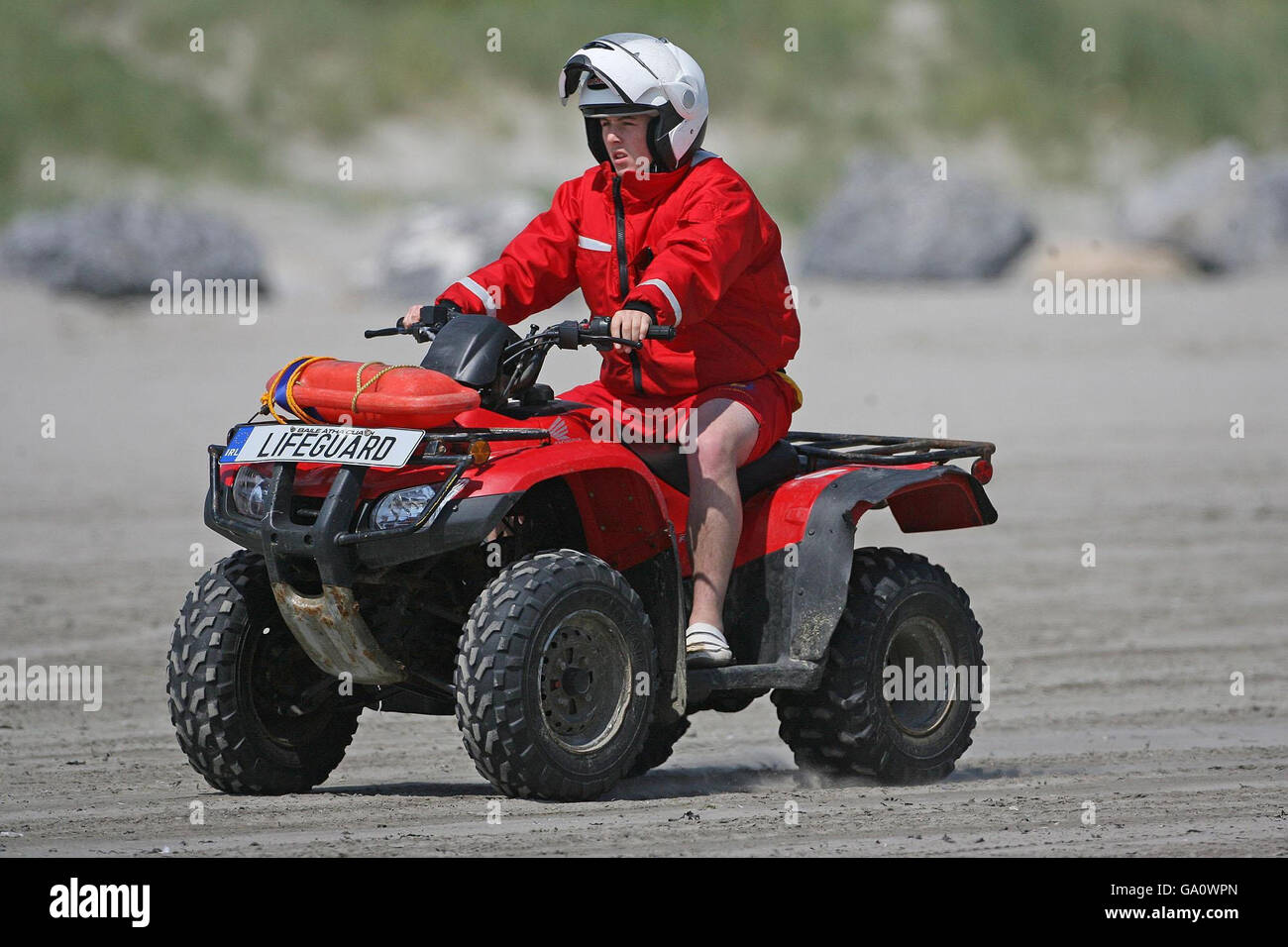 Ein Rettungsschwimmer auf einem Quad-Bike fährt entlang Dollymount Strand, Dublin, das es versäumt hat, den begehrten Blue Flag-Status für ökologische Exzellenz zu sichern. Stockfoto