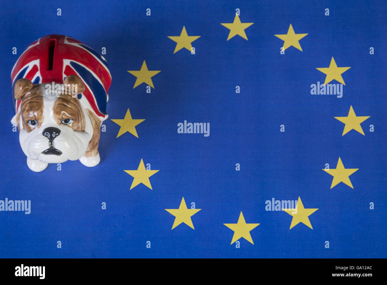 Eine britische Bulldogge Piggy Bank sitzt außerhalb der Eu-Flagge Stockfoto