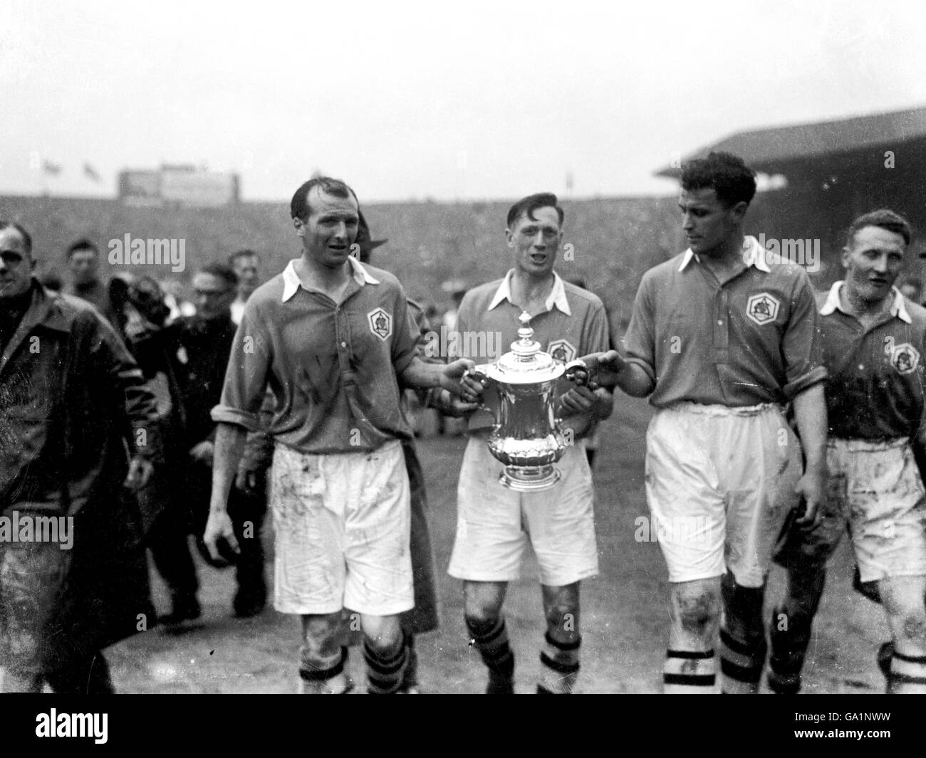 (L-R) die Arsenals Wally Barnes, Joe Mercer und Les Compton tragen den FA Cup nach ihrem Sieg von 2-0 zurück in die Garderobe Stockfoto