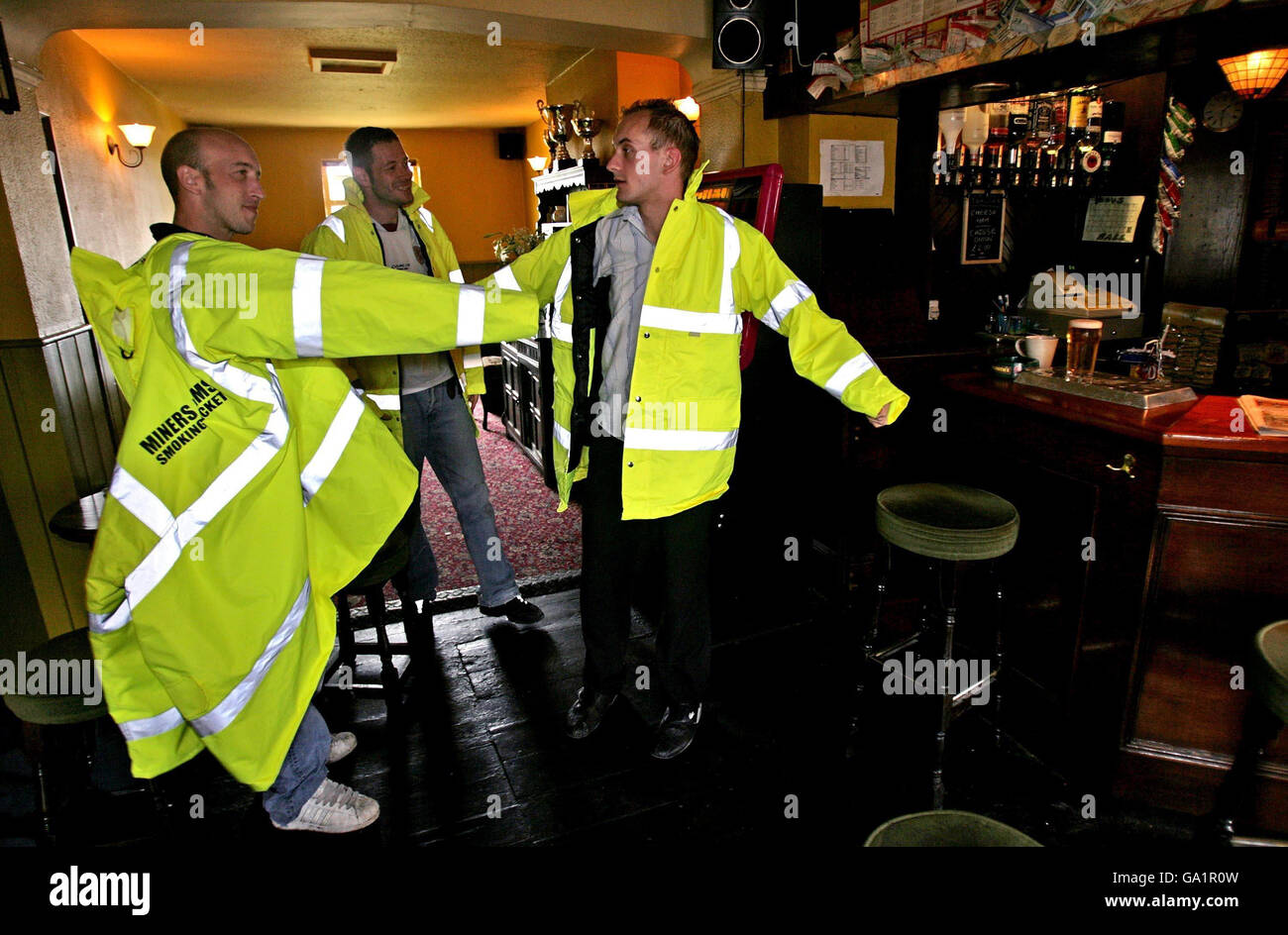 Raucher im The Miners Arms Bristol, das an einer belebten Hauptstraße liegt, sind mit Jacken ausgestattet, um sie vor dem Verkehr zu schützen, wenn sie nachts außerhalb des öffentlichen Hauses rauchen. Stockfoto