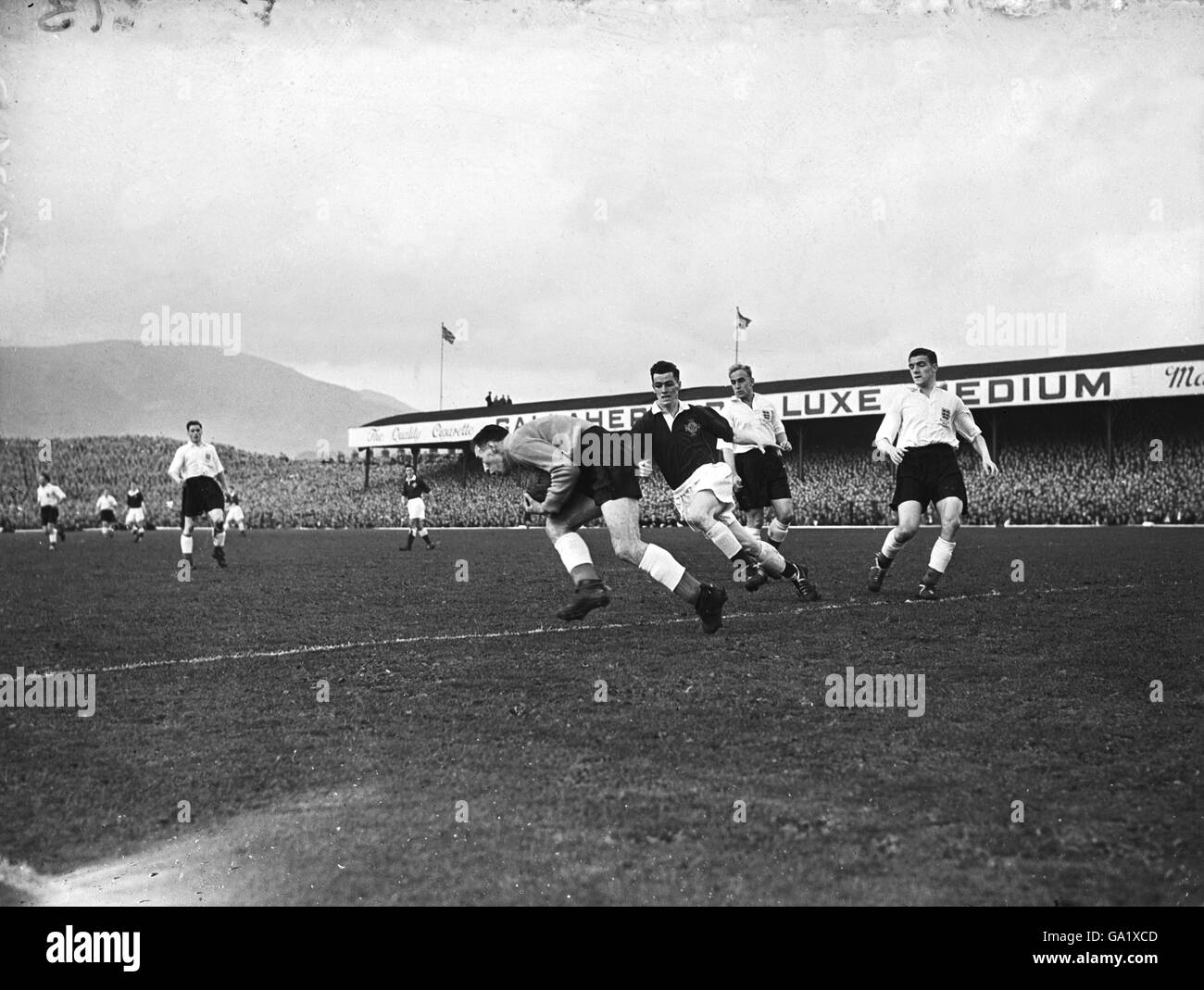 Englands Torhüter Ray Wood (l) sammelt den Ball unter Druck, beobachtet von den Teamkollegen Billy Foulkes (r) und Billy Wright (zweite r) Stockfoto