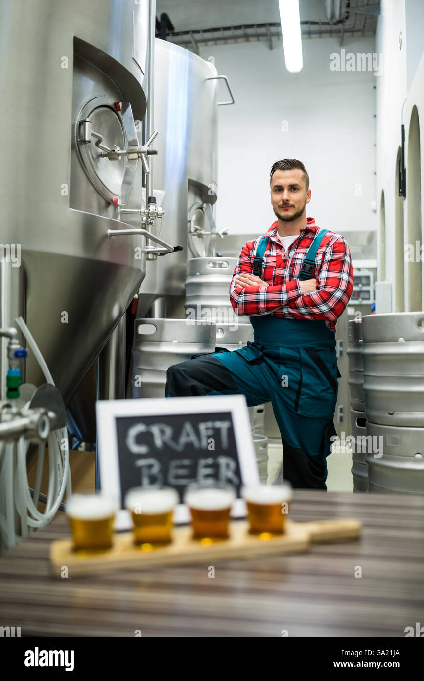 Vier Gläser Bier Bier Sampler Tablett und Brauer im Hintergrund stehen Stockfoto