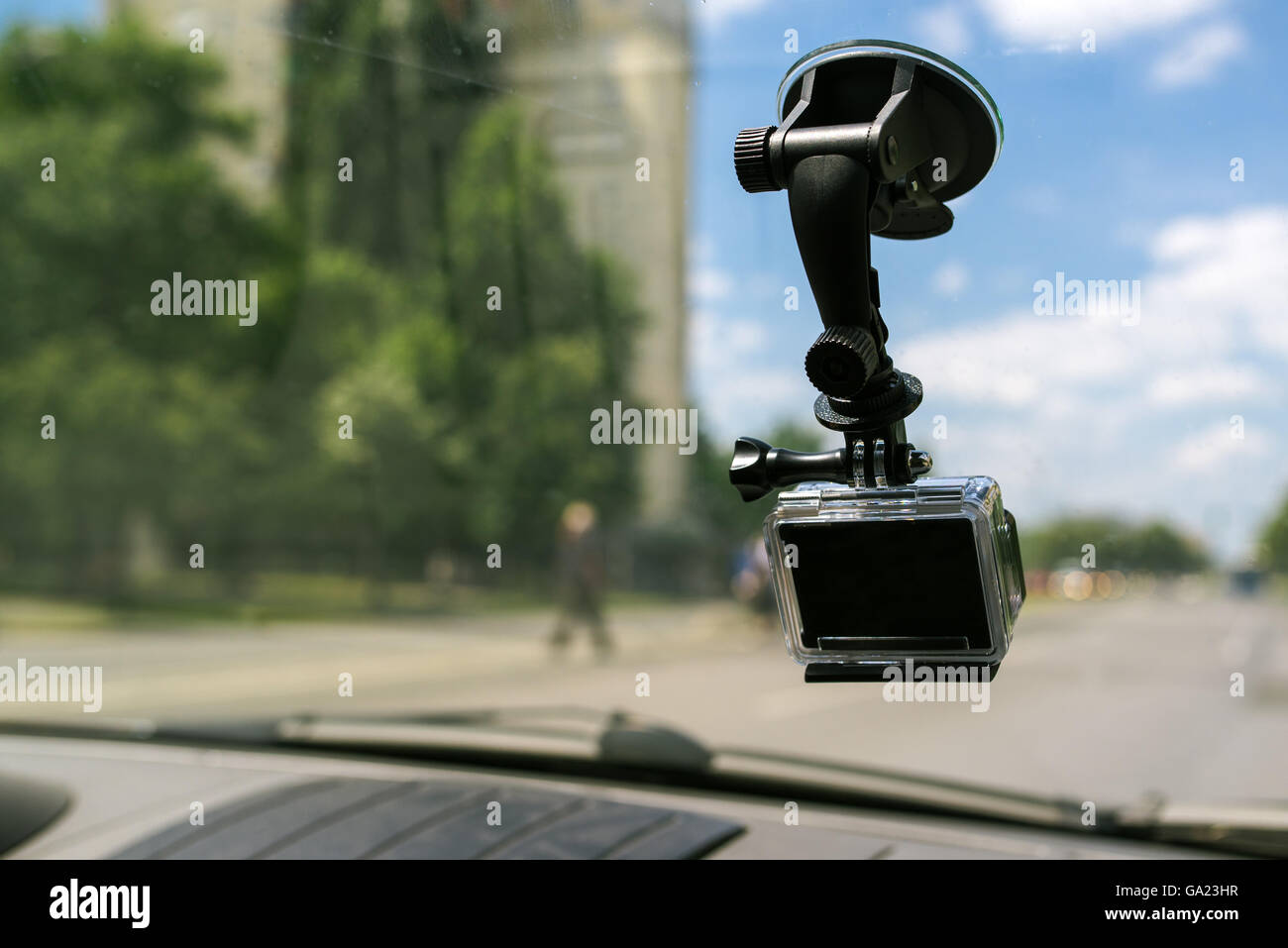 Action-Kamera mit Saugnapf am Autofenster Windschutzscheibe, filmt das Fahrerlebnis im städtischen Verkehr Umwelt Stockfoto