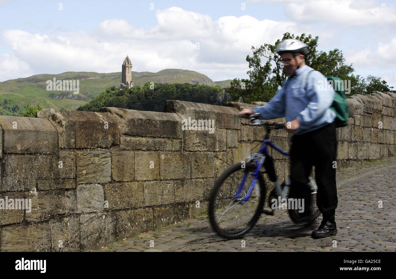 Abgebildet ist eine allgemeine Ansicht eines Touristen auf dem Alte Stirlingbrücke, die den Fluss Forth bei Stirling überquert Mit dem Wallace Monument (hinten) Stockfoto