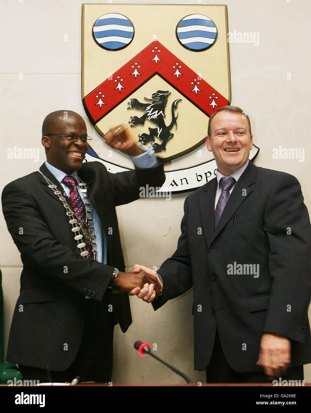 Der gebürtige Nigerianer Rotimi Adebari schüttelt sich die Hände mit dem auslaufenden Sinn Fein Bürgermeister von Portlaoise Brian Stanley, um Irlands erster schwarzer Bürgermeister in den Stadtratbüros zu werden. Stockfoto