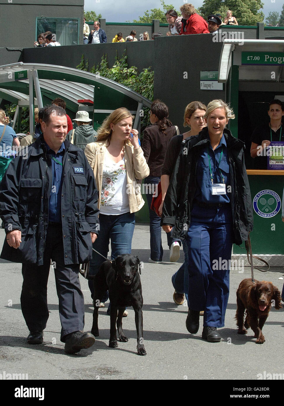 Sicherheitskräfte mit ihren Sniffer Dogs laufen während der All England Lawn Tennis Championship in Wimbledon um Wimbledon herum. Stockfoto