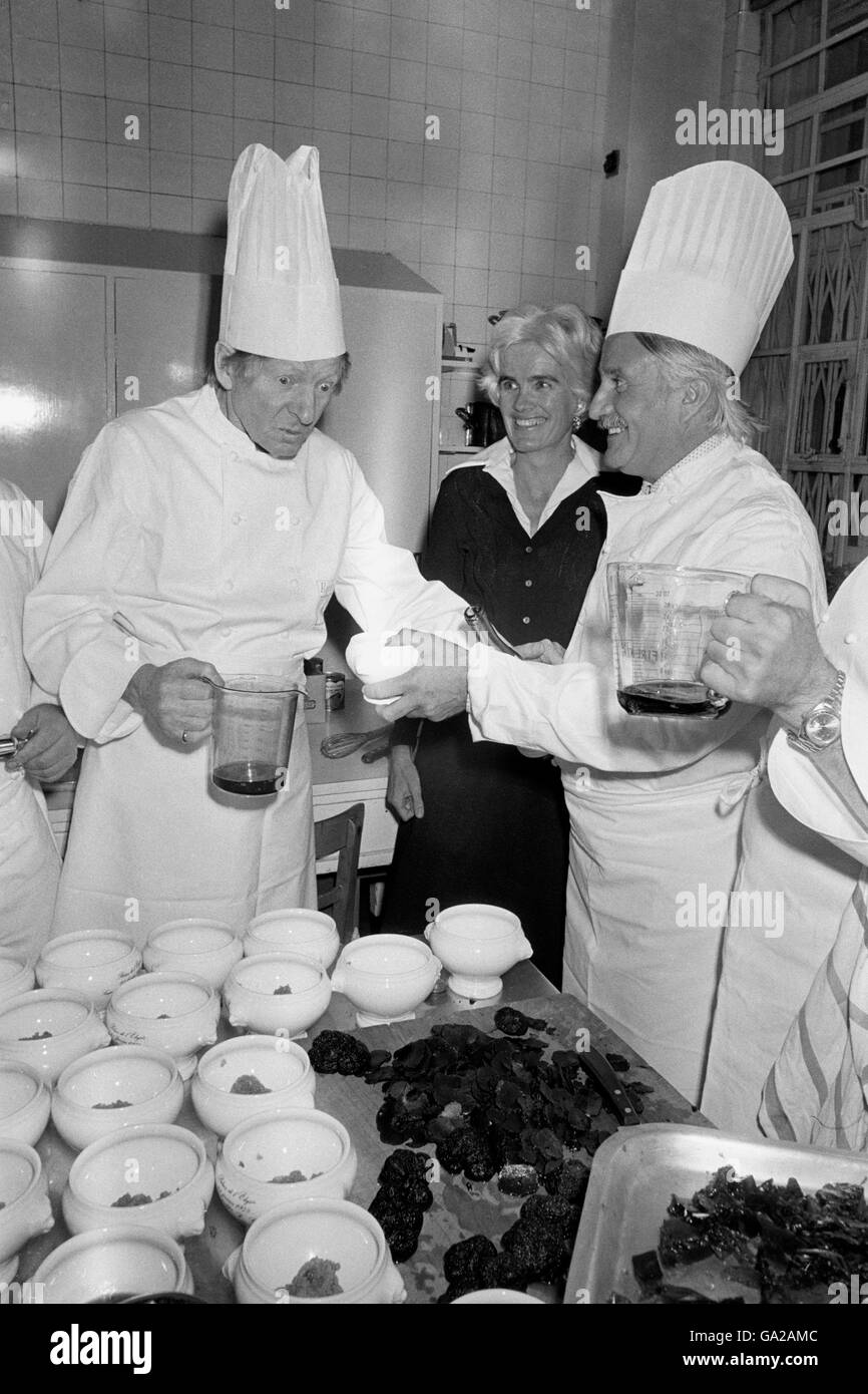 Der Mann, der zum Abendessen kam und dann in die Küche eindrang, ist der amerikanische Schauspieler Danny Kaye, Der gerade im Winfield House, der Residenz der American Ambassadors im Regent's Park, in dem er heute Abend bei einer kleinen privaten Party von Botschafter Elliot Richardson und seiner Frau Anne zu Ehren war, in die Action eingreifen musste. Mrs Richardson sieht Danny (links), selbst ein erfahrener Koch, an - besteht darauf, Roger Verge, einem der vier besten französischen Köche, bei der Zubereitung der Mahlzeit zu helfen. Das Menü war das gleiche, das dem französischen Presaident Giscard d'Estaing im letzten Februar im Elysee Palace in Paris serviert wurde. Stockfoto