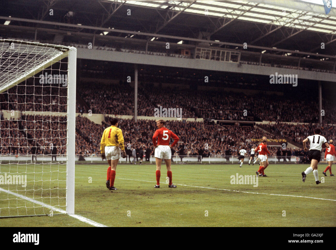 England gegen Westdeutschland - Weltcup-Finale 1966 - Wembley-Stadion. Englands Gordon Banks und Jackie Charlton stehen niedergeschlagen, nachdem der westdeutsche Helmut Haller (nicht abgebildet) die Wertung eröffnet hat Stockfoto