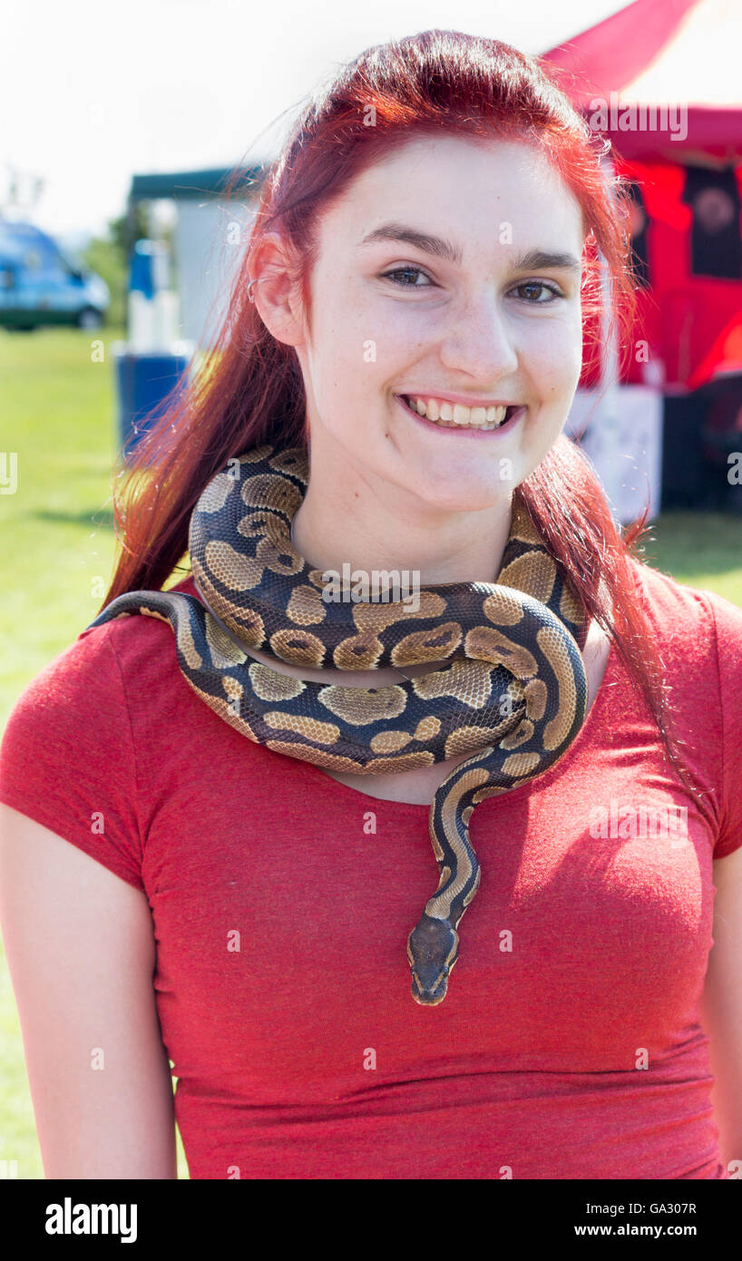 Junge Frau trägt eine lebende Schlange wie eine Kette um den Hals Stockfoto