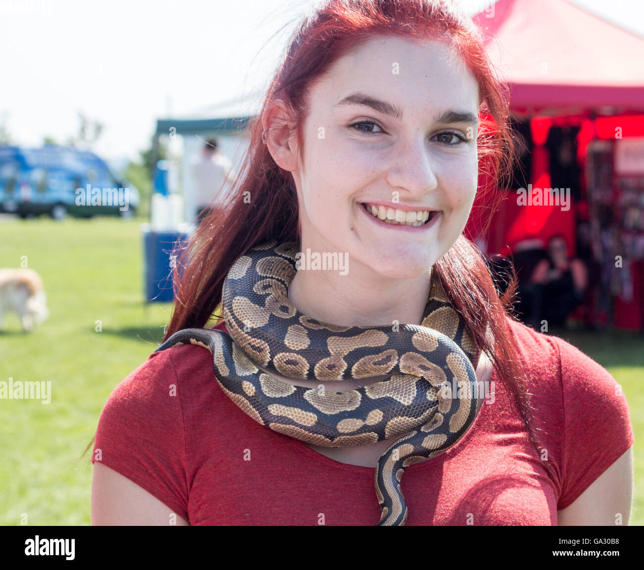 Junge Frau trägt eine lebende Schlange wie eine Kette um den Hals Stockfoto