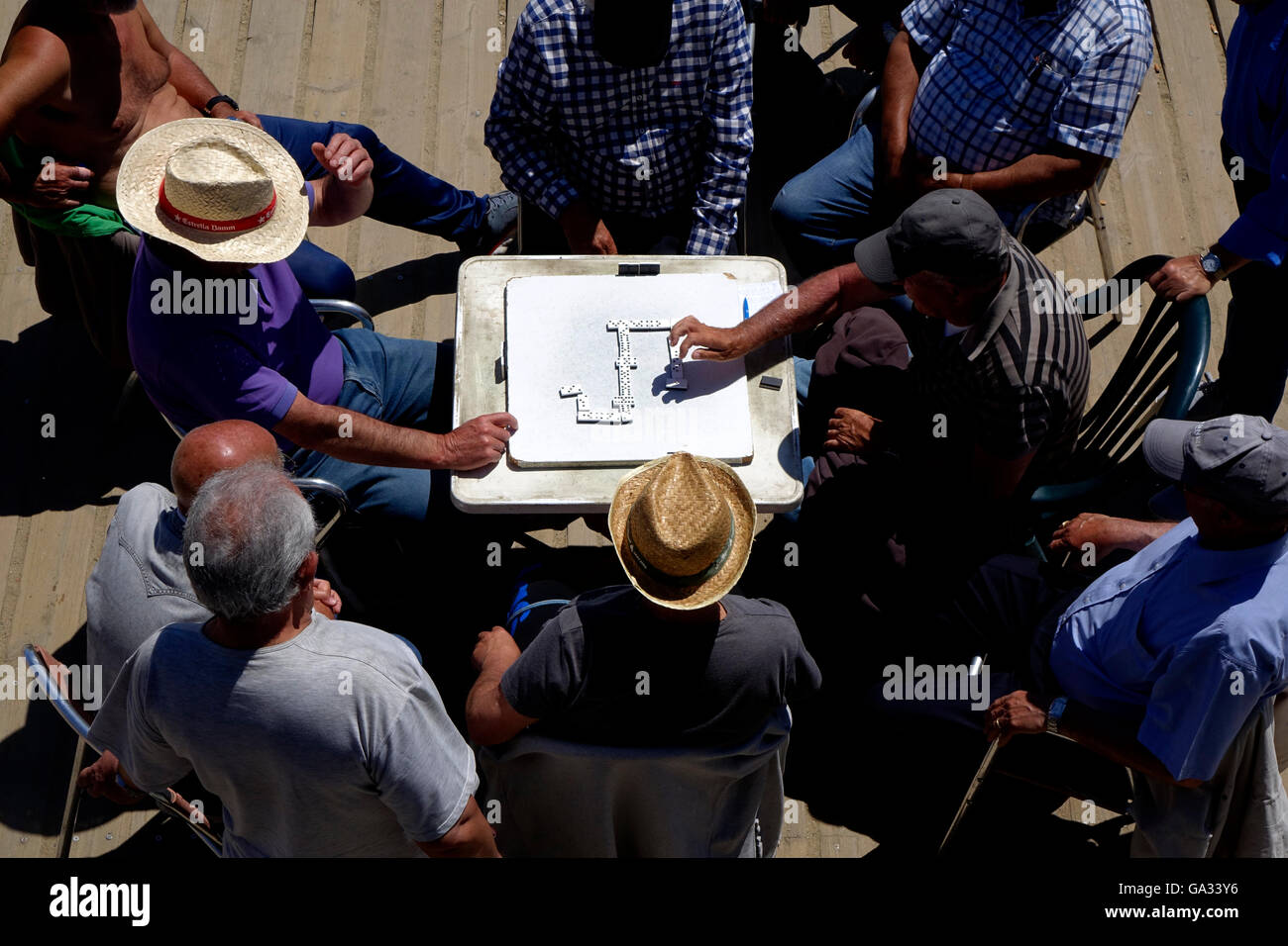 Eine Gruppe von Männern zusehen, wie zwei Domino Spieler spielen auf der Platja Nova Icaria Strand in Barcelona. Stockfoto