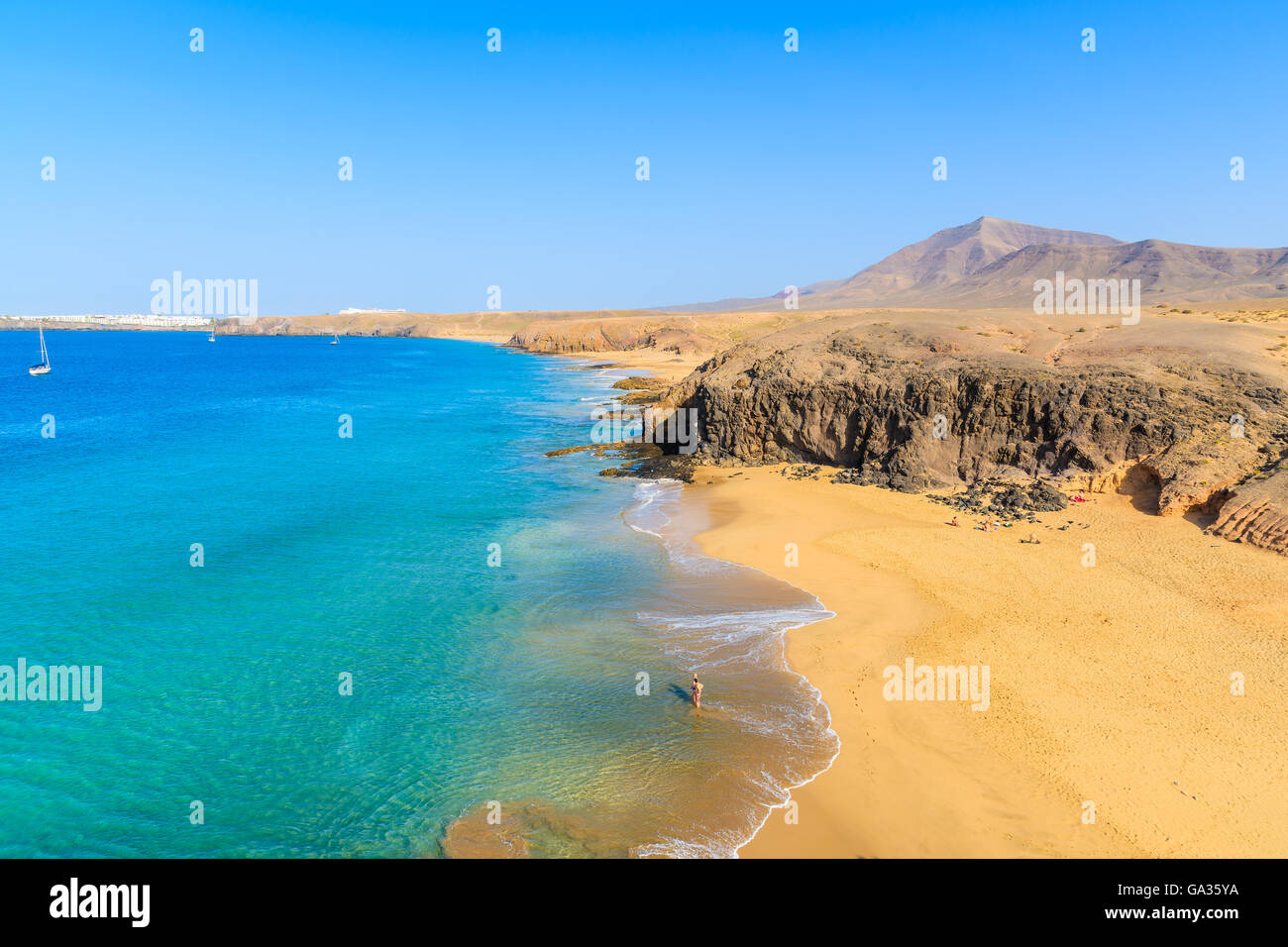 Paar Leute in türkisblauem Meereswasser am Papagayo Strand, Lanzarote, Kanarische Inseln, Spanien Stockfoto
