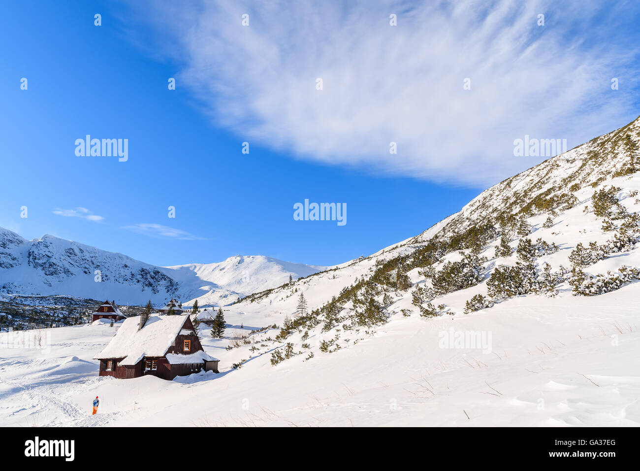 Backpacker vor hölzerne Hütte in Winterlandschaft von Gasienicowa Tal, Tatra-Gebirge, Polen Stockfoto