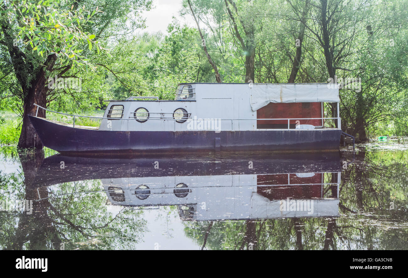 Altes Boot schwimmend im Fluss Stockfoto