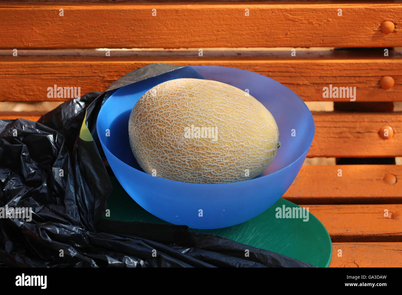 Ungeschälte Melon Frucht in einem blauen Plastikschüssel Stockfoto