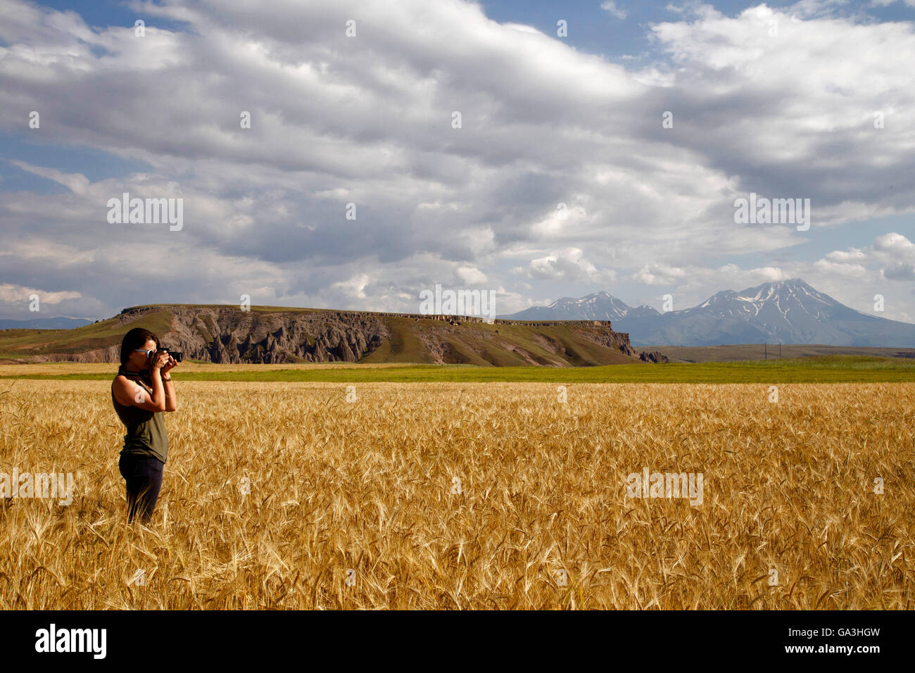 Das Fotografen-Mädchen, Cappadocia Erfassung ist, Feld auf dem Hintergrund Hasandag Berg und erstaunlichen Himmel. Stockfoto