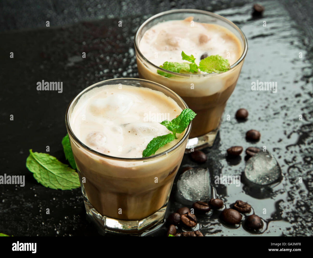 Eiskaffee im Glas mit Eiswürfeln und frische Minze und Kaffee Bohnen Stockfoto