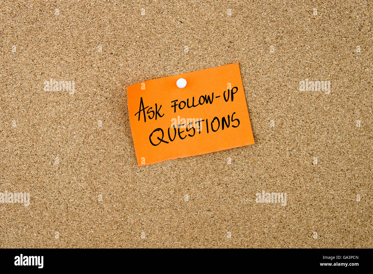 Fragen Sie Follow-up Fragen geschrieben am orangefarbenen Papier Hinweis Hinweis auf Pinnwand mit weißen Reißzwecke, Kopie Speicherplatz angeheftet Stockfoto
