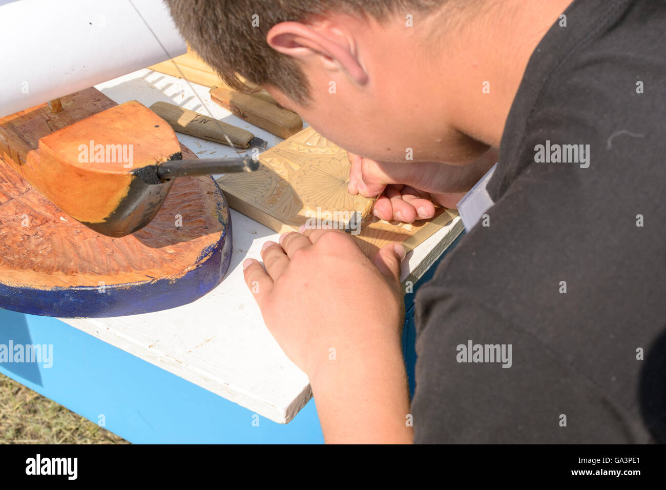 Kind mit Handwerkzeugen, Holz für Bastelaktion schnitzen Stockfoto