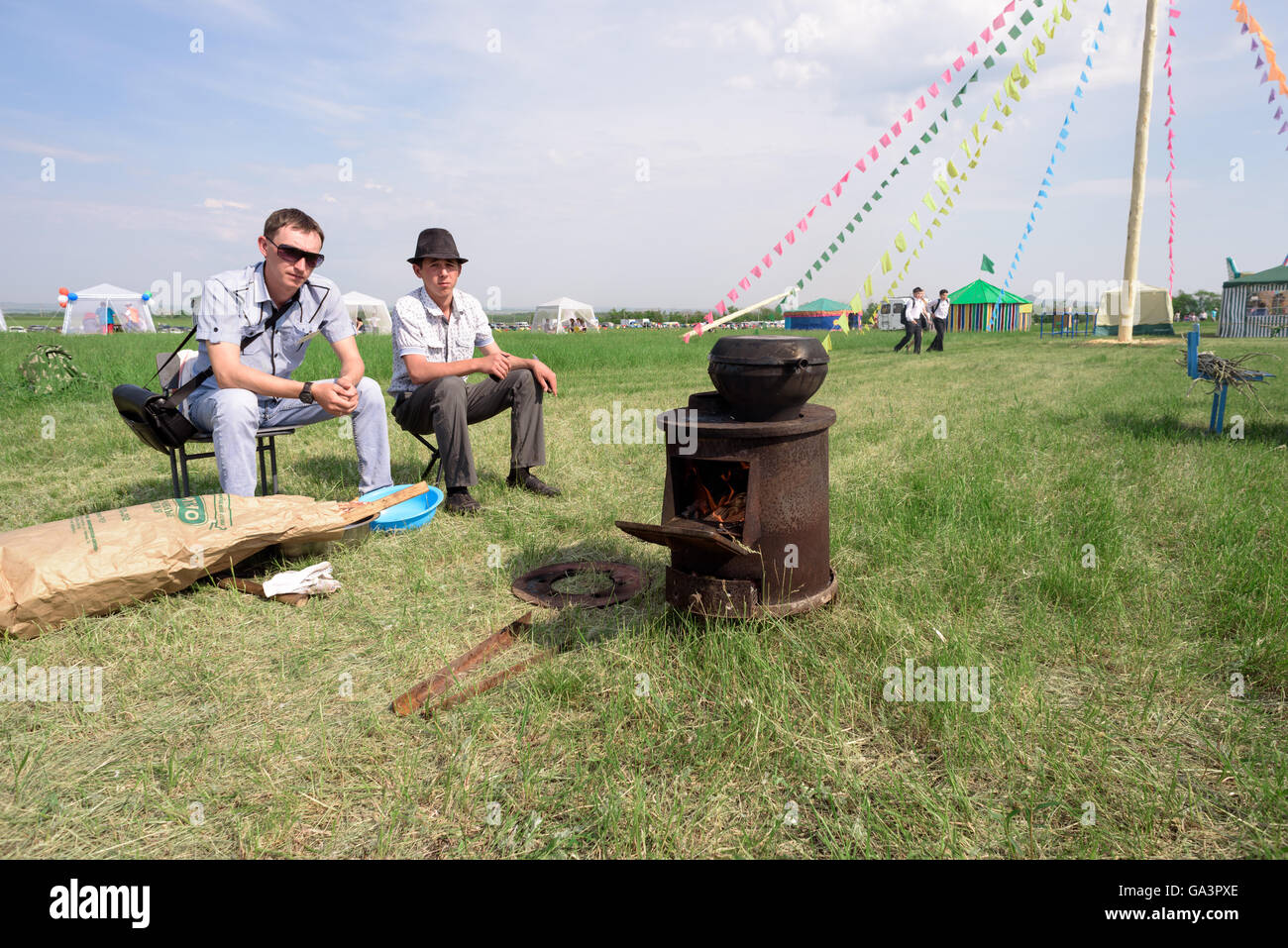 Zwei junge Männer sitzen durch eine outdoor-Kocher Stockfoto