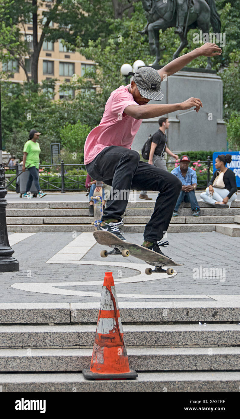 Skateboarder üben Sprünge über Leitkegel im Union Square Park in New York City Stockfoto