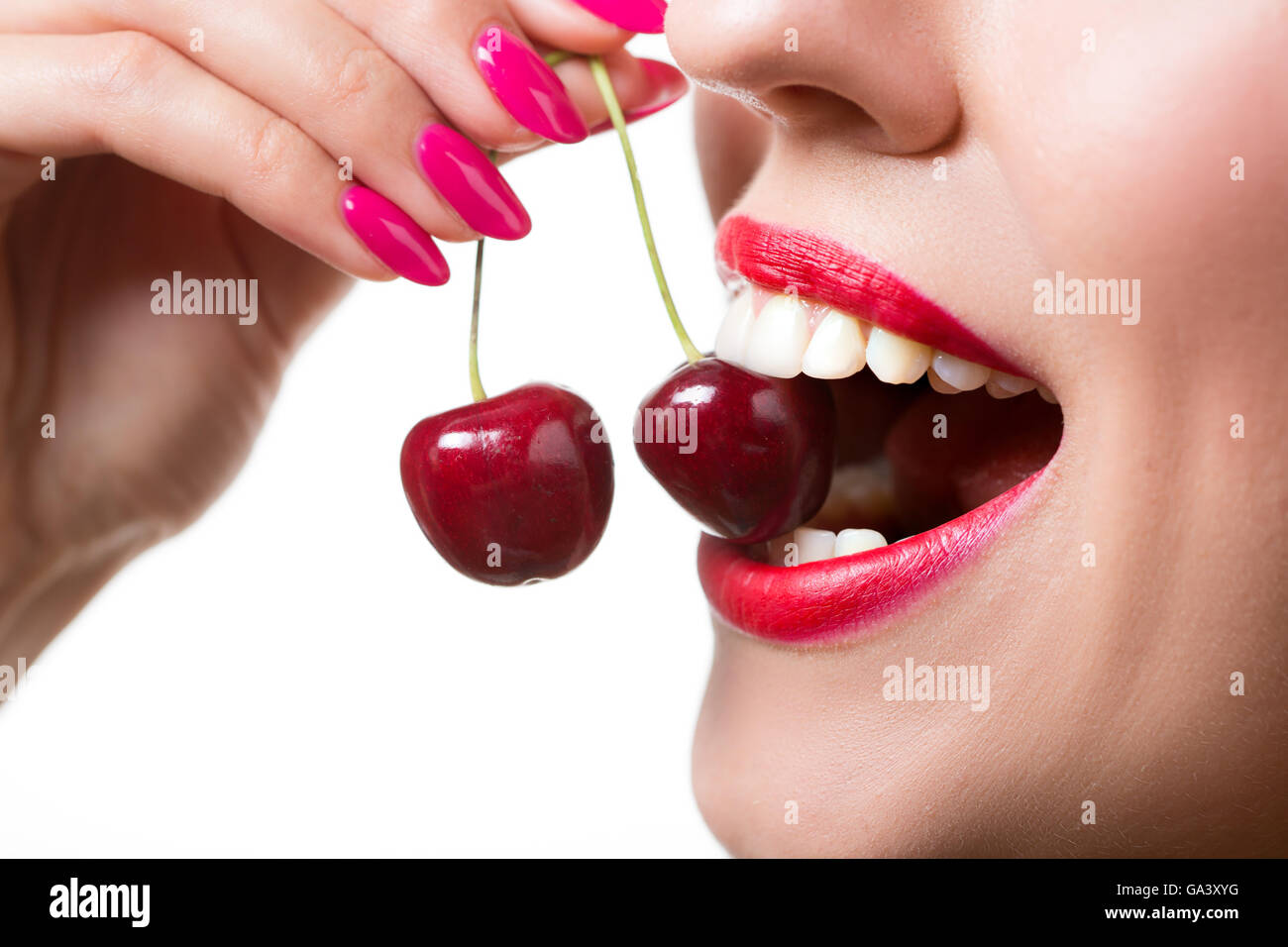 Lippen und Zunge leckt zwei Beeren des Mädchens Stockfoto