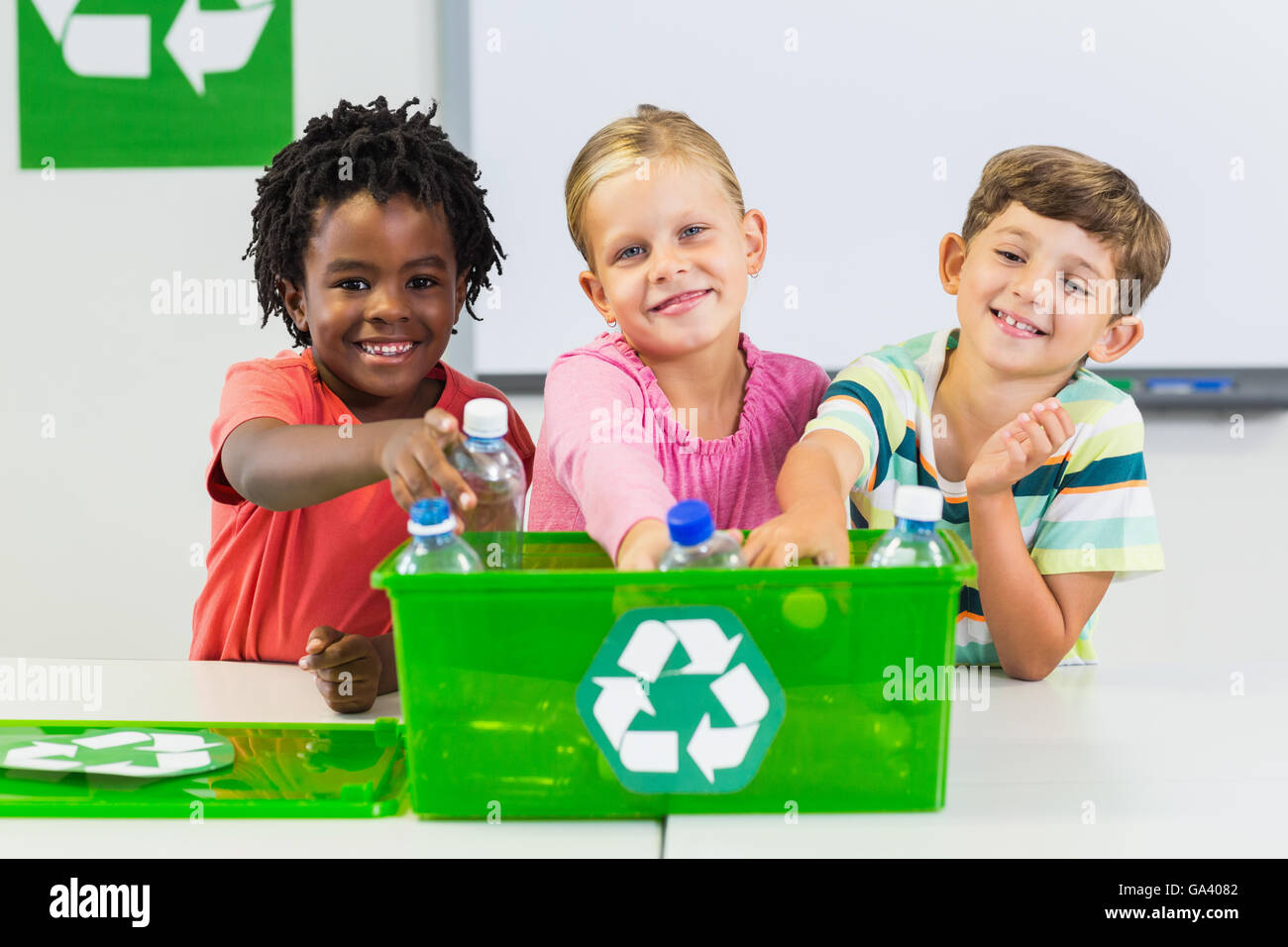 Kinder halten Recycling-Flasche im Klassenzimmer Stockfoto