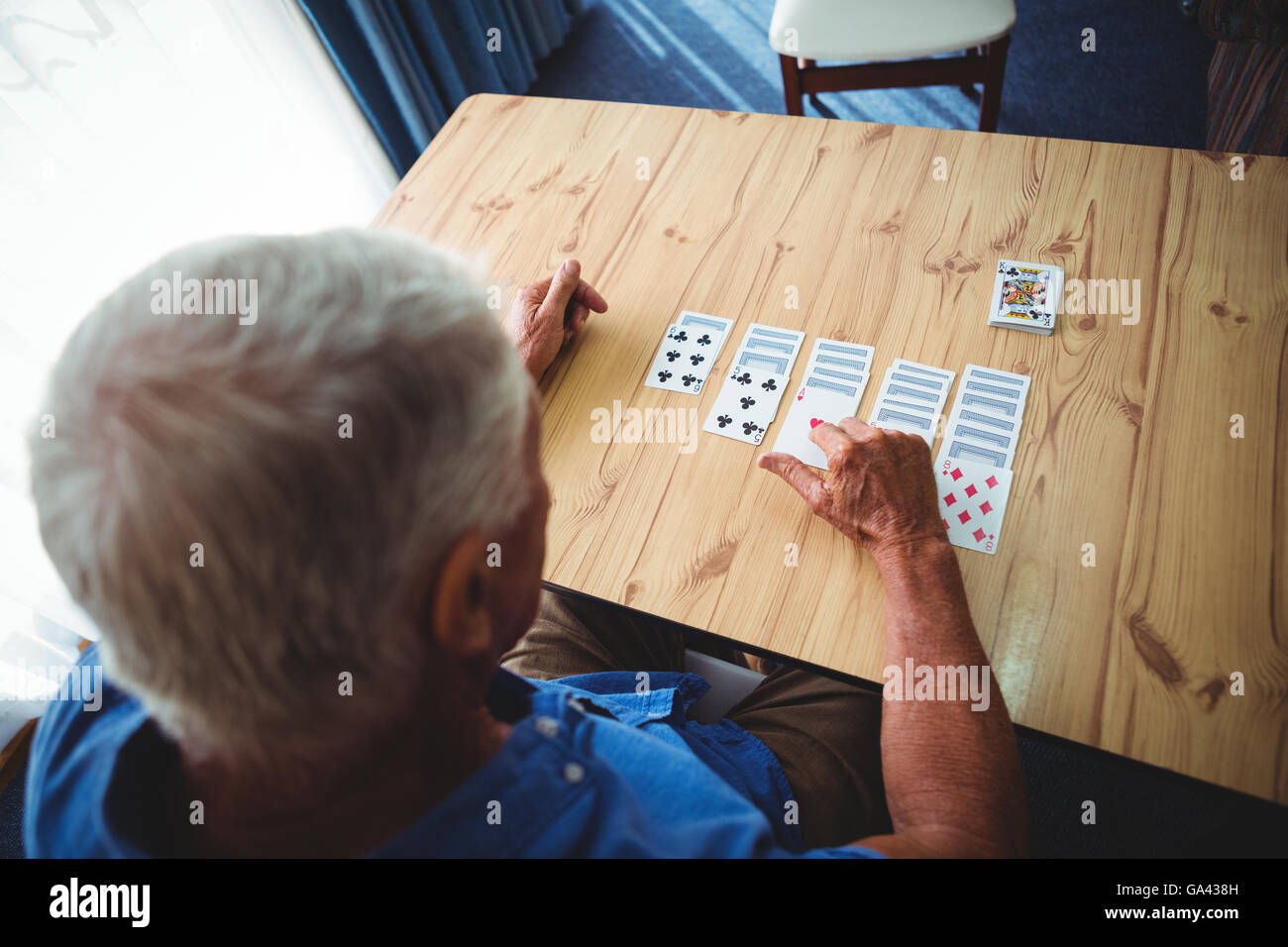 Senior woman Spielkarten auf dem Tisch Stockfoto