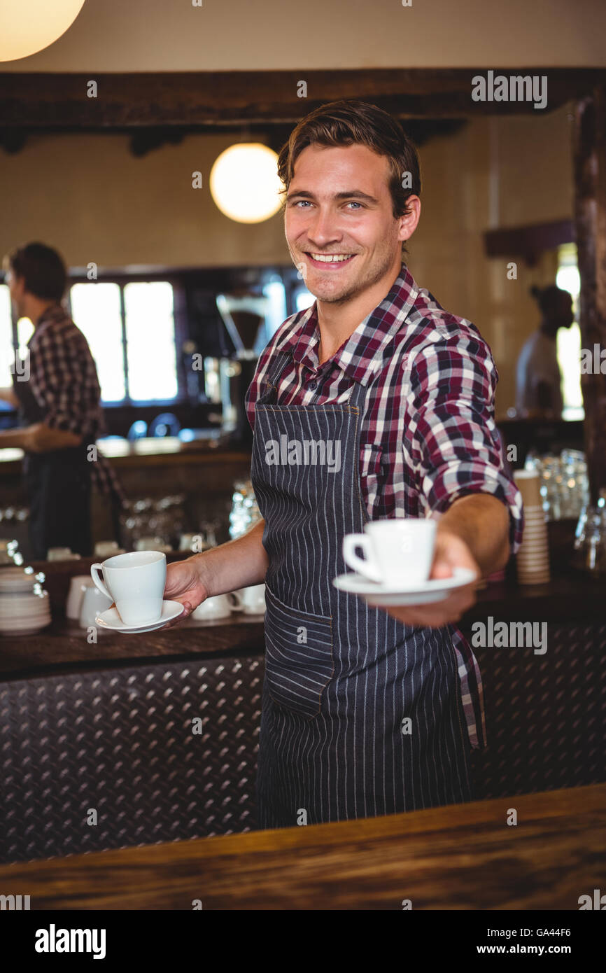 Kellner, die Übergabe eines Kaffees Stockfoto