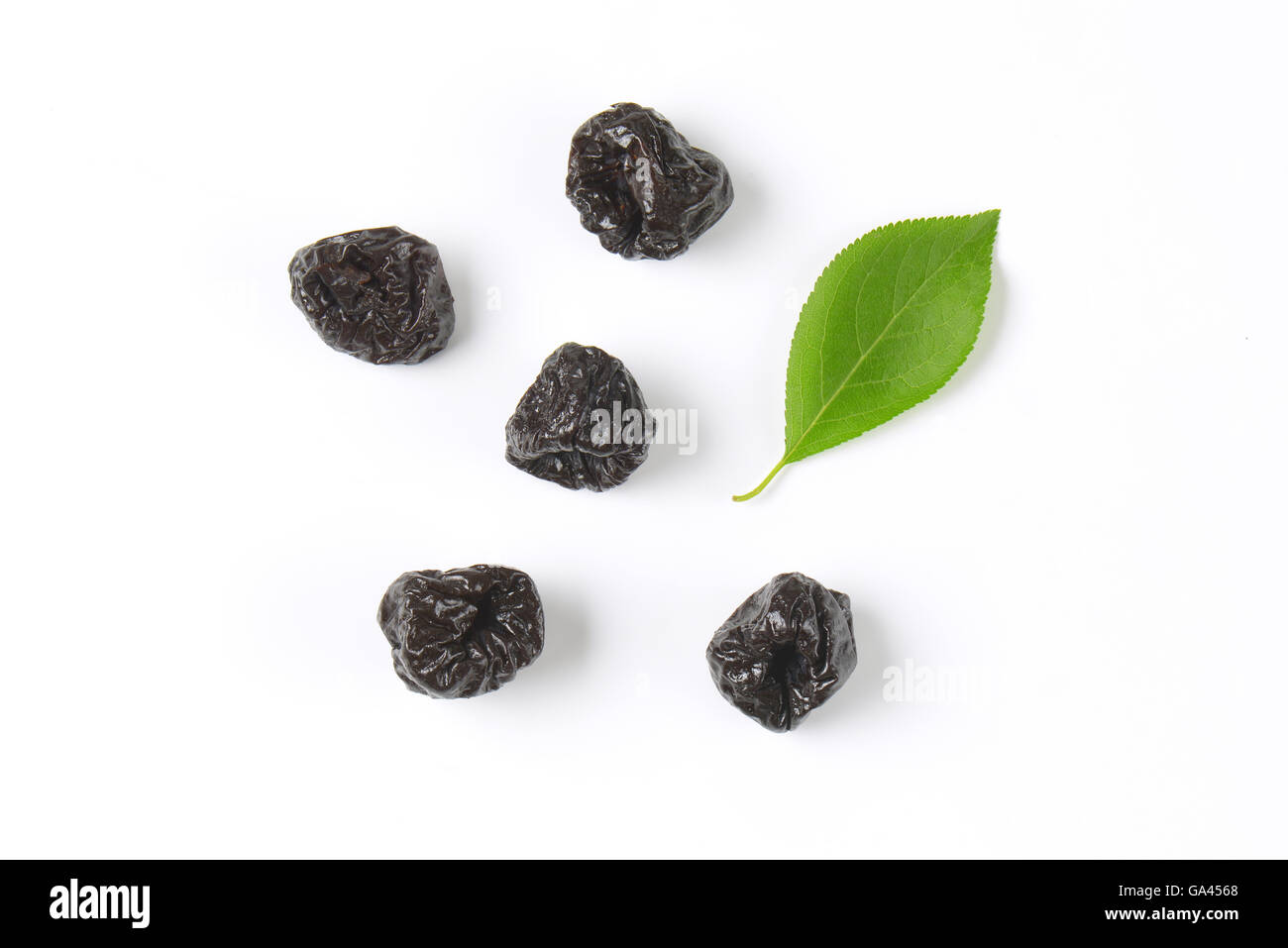getrocknete Pflaumen und Pflaumen Blatt auf weißem Hintergrund Stockfoto