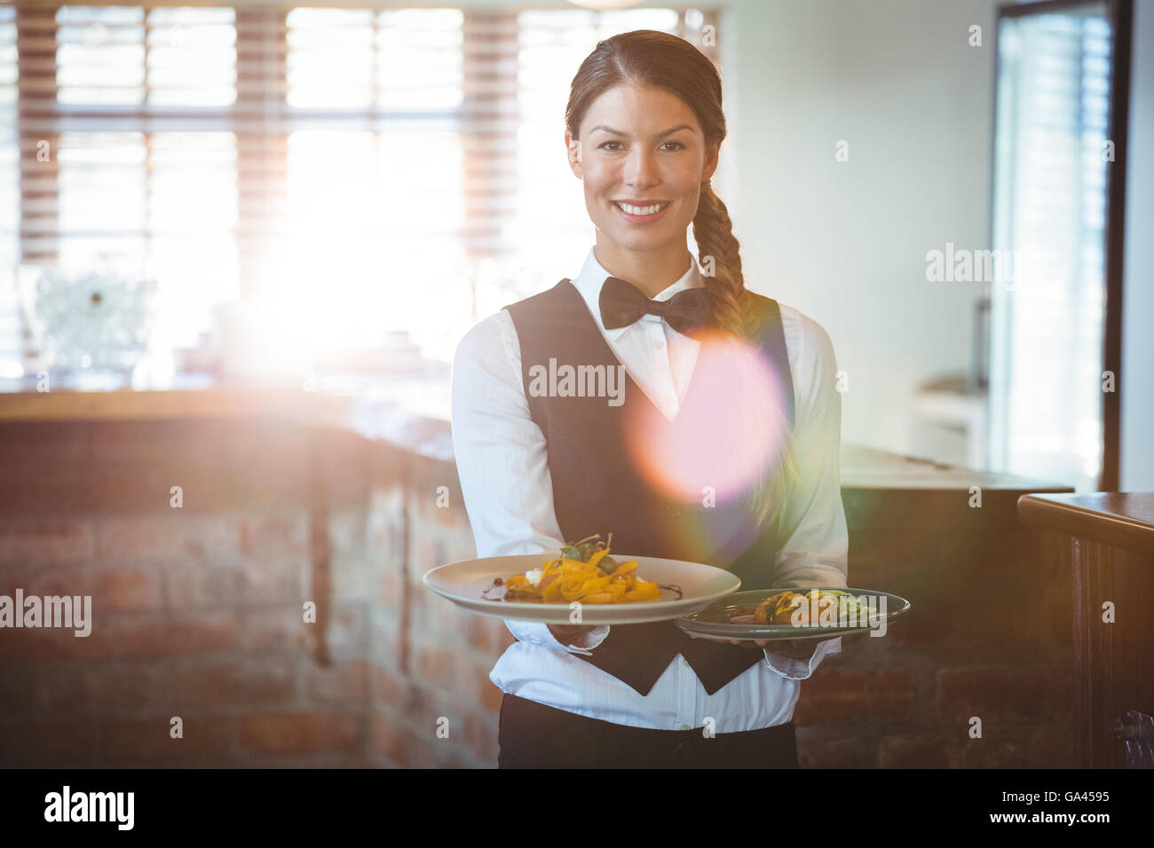 Kellnerin Holding Gerichte Stockfoto