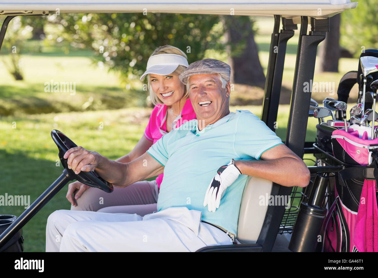Fröhliche ältere Golfer paar sitzt im Golfbuggy Stockfoto