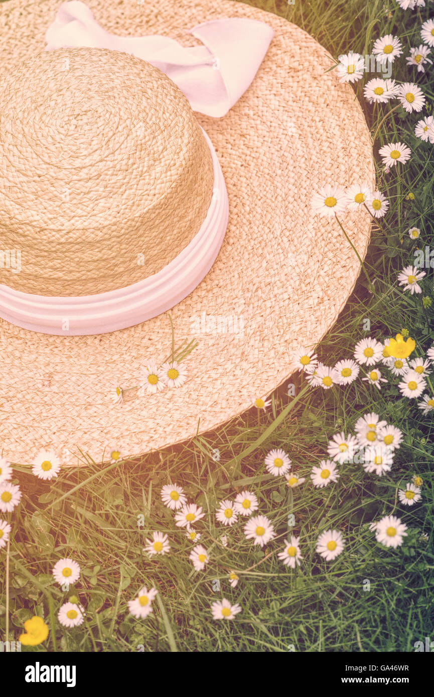 Strohhut auf einem Gänseblümchen Rasen mit einem Vintage Sonnenlicht-filter Stockfoto
