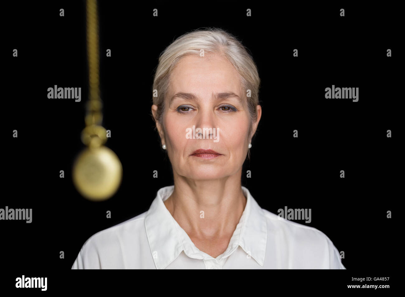 Ältere Frau hypnotisiert mit pendulu Stockfoto
